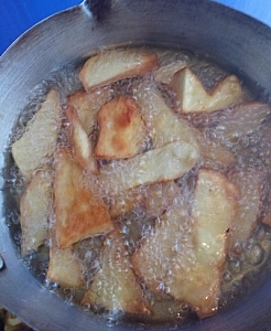 Frying of potato chips in a pan