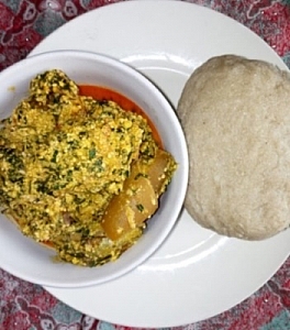 Egusi soup being served with cassava flour (Alebo)