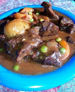 Beef stew being dish into a plate