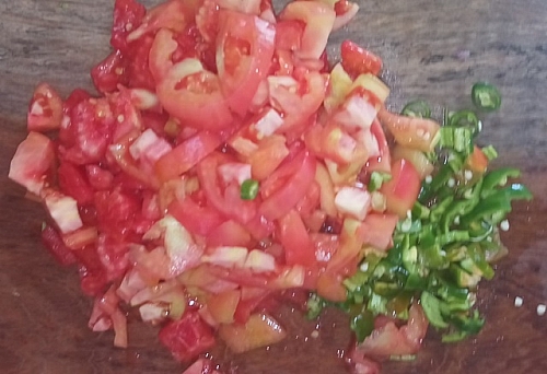 Chopping of salsa vegetables. you can decide to blend the onion and tomatoes into chunky consistency for the salsa.
