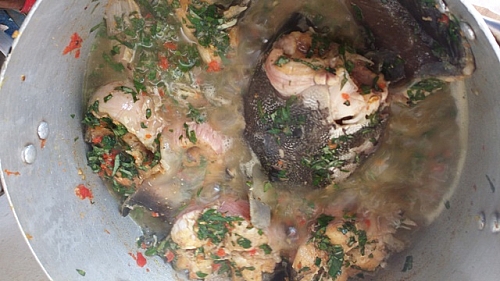 Photo of After adding the leaves to the catfish pepper soup, stir gently to avoid breaking the fish After adding the leaves to the catfish pepper soup, stir gently to avoid breaking the fish