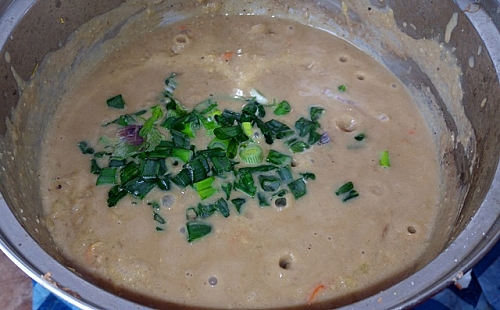 Spring onion is added as the last ingredient to pumpkin porridge
