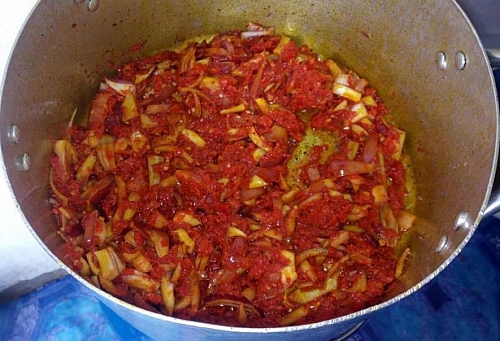 Frying of onions and blended peppers for efo riro