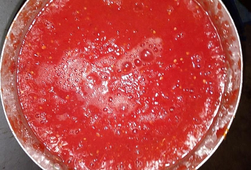 Boiling of blended tomato for chicken stew recipe