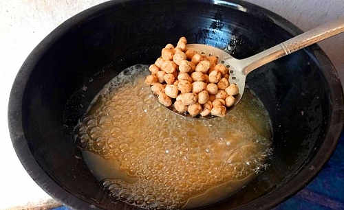 All the peanuts should be evenly brown before removing the oil