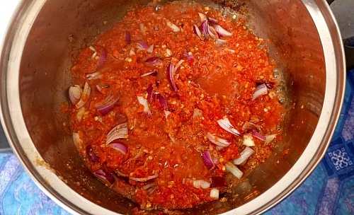 Once the water has reduced from the tomato, add onions and crayfish