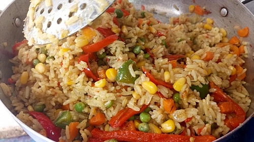 Stir-frying of coconut rice in spicy vegetable sauce