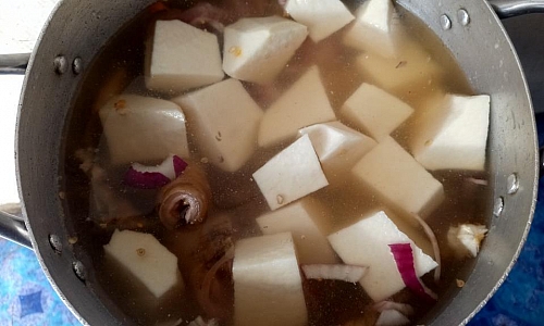 Boiling of yam and goat meat for ofe nsala soup