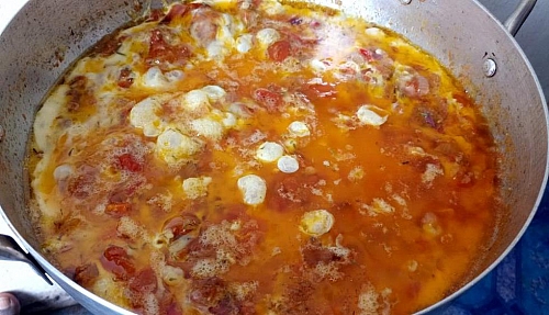 Photo of Pour the egg circularly to cover all the content in the pan Pour the egg circularly to cover all the content in the pan