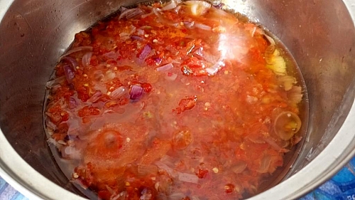 Once the onion is fried and gives out a nice fragrance, add the blended tomato and pepper into the oil and fry as well