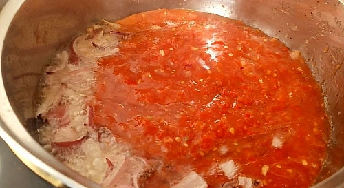 Frying of onion and tomato mix for kpomo stew